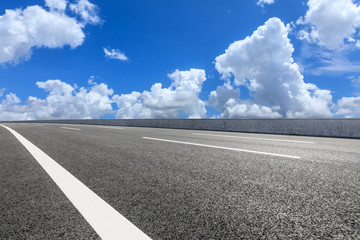 Fototapeta premium Asphalt highway road and blue sky with white clouds