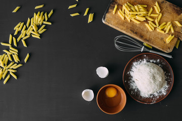 the ingredients for making pasta are on the table. flour, chicken eggs.