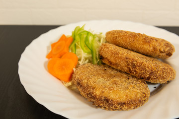 Homemade vegetable poak croquettes with salad, minced poak, potato and carrot in the croquettes. 