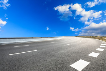 Asphalt highway road and blue sky with white clouds