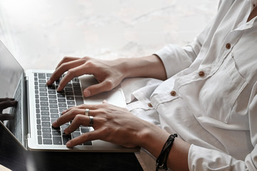 Closeup man typing on laptop computer.