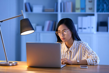Young Asian student preparing for exam late in evening