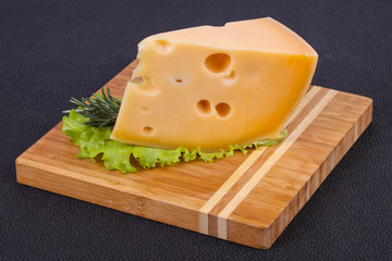 Maasdam cheese  in the board served salad leaves