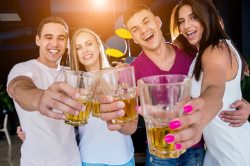 Cheerful friends in the pub. Drinking beer, talking, having fun.