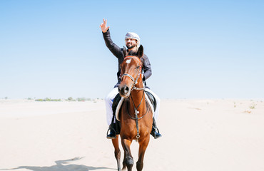 Arabian man with traditional clothes riding his horse