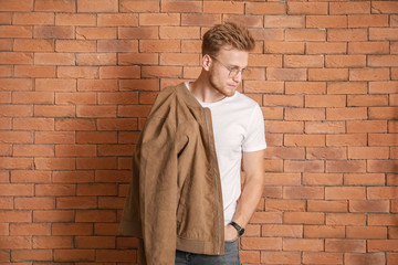 Man in stylish t-shirt against brick wall