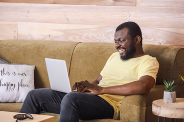 African-American blogger with laptop at home