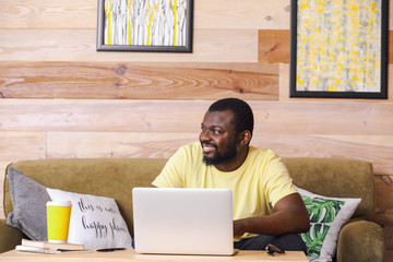 African-American blogger with laptop at table