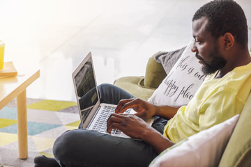 African-American blogger with laptop at home