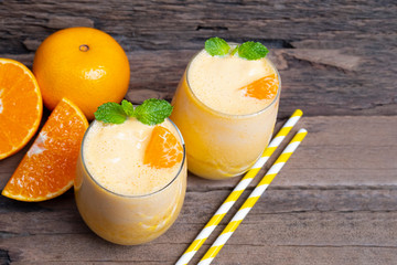 Orange smoothies yellow colorful fruit juice milkshake blend beverage healthy high protein the taste yummy In glass,drink to lose weight drink episode on wooden background from top view.
