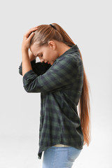 Woman having panic attack on light background