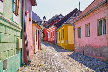 Fototapeta na wymiar Stone paved road and colorful houses