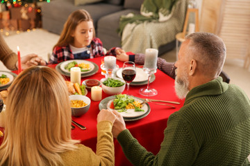 Family praying before having Christmas dinner at home