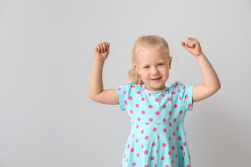 Happy little girl on light background