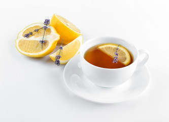 Cup of hot tea with lemon and lavender on white background