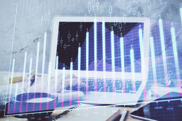 Forex graph with businessman working on computer in office on background. Concept of hardworking. Double exposure.