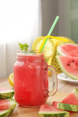 Mason jar of fresh watermelon juice on table