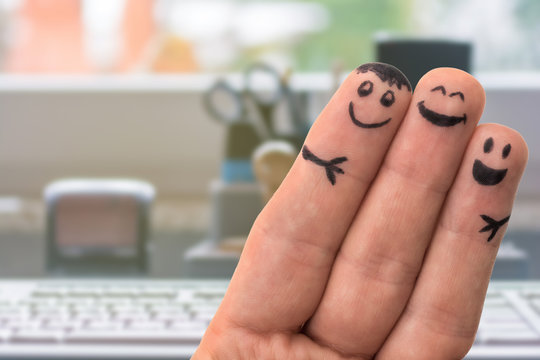 Drei Fingermännchen in einem Büro zum Thema kollegialer Zusammenhalt und Teamwork