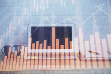 Forex market graph hologram and personal computer on background. Multi exposure. Concept of investment.