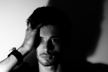 Young man teenager pretty look the camera black and white shadows and light
