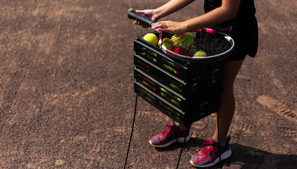 Close-up of tennis player near box of balls