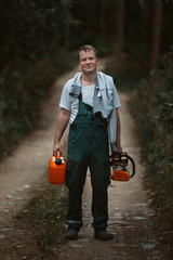 a man sawing a tree with a chainsaw. removes forest plantations from old trees, prepares firewood.