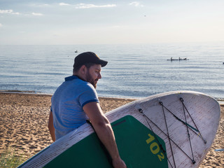 Attractive Man WITH SUP Board, Blue SEA