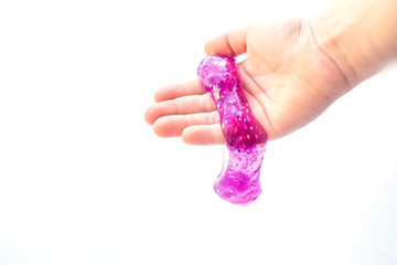 Modern toy called slime. Child playing transparent purple slime. Hands holding a mucus isolated on a white background. Selective focus.