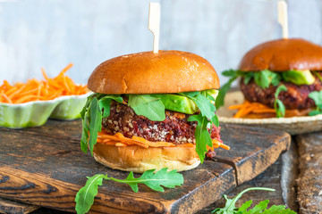 Vegetarian beetroot burger with avocado and carrot slaw in brioche bun