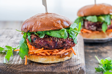 Vegetarian beetroot burger with avocado and carrot slaw in brioche bun