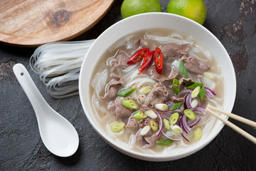 Traditional vietnamese pho bo soup, studio shot on a brown stone background, elevated view