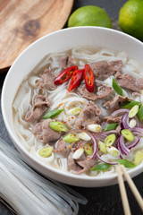 Close-up of a bowl with vietnamese pho bo soup, vertical shot, selective focus