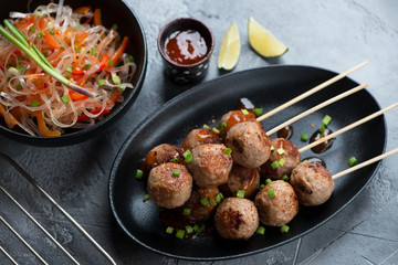 Traditional vietnamese nem nuong with a bowl of pho noodles, horizontal shot on a grey concrete background