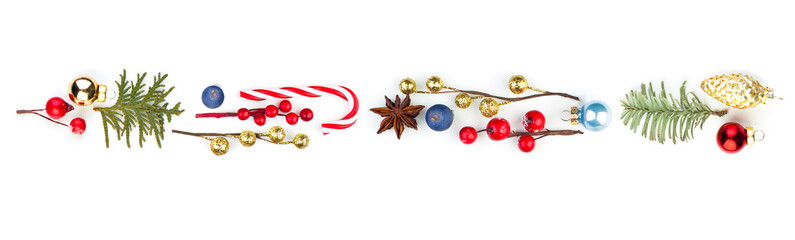 Christmas composition with red holly berries, green fir branch and Xmas candy on white background