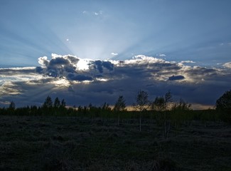 bright sunset in spring through the clouds, Russia.