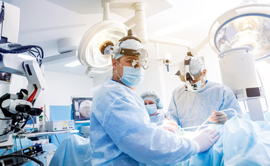 Portrait of spinal surgeon in operating room with surgery equipment.