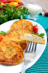 Tasty fried hot sandwiches with minced chicken on a white plate. A piece on a fork.