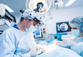 Spinal surgery. Group of surgeons in operating room with surgery equipment. Laminectomy