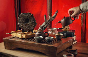 Obraz na płótnie Canvas tea table with instruments teapots cups pancake and tea Shen Puer