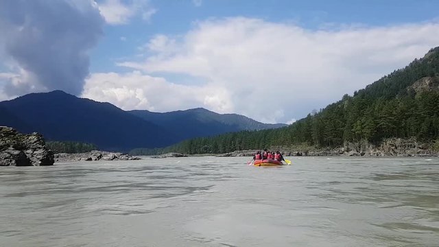 Beautiful view of the rafting on the Katun river in Altai. Rafting in Russia. Waves and rocks on the river. Beautiful clouds and nature. Interesting active vacation
