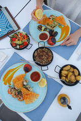 Woman squeezing lemon over a meal in the Mediterranean restaurant