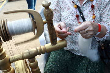 Woman spins thread of wool