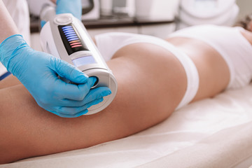  woman getting slimming body treatment at beauty clinic.