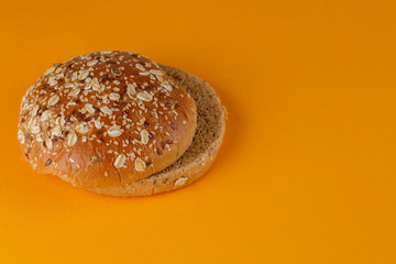 Rye bun empty isolated. American food classic rye round burger bread isolated on orange background. Grilled burger bun top.