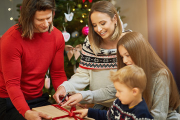 Beautiful family with presents over Christmas tree