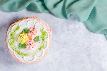 Fototapeta na wymiar Beautiful delicious cake decorated with flowers in pastel colors on wooden table with peonies, top view