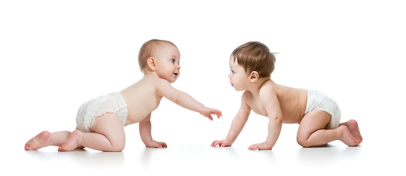 Two cute children looking at each other. Babies weared diaper. Infants isolated on white