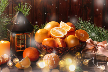 Christmas still life with lantern, burning candle, christmas tree branches, fruits and pine cones.