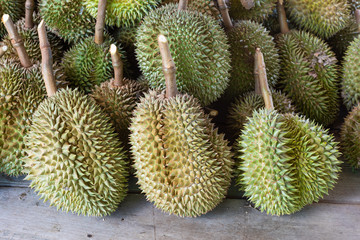 Naklejka na ściany i meble Heap of durian fruits sit on wood table in market.