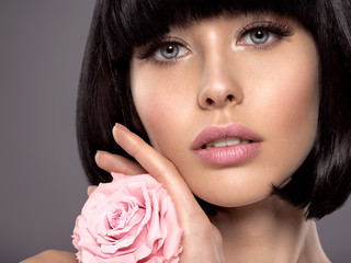 Woman with beauty short black hair holding rose flower.